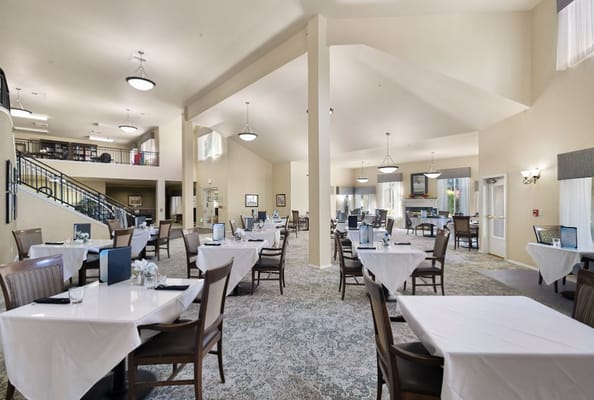 Bright dining area with white tablecloths and wooden chairs