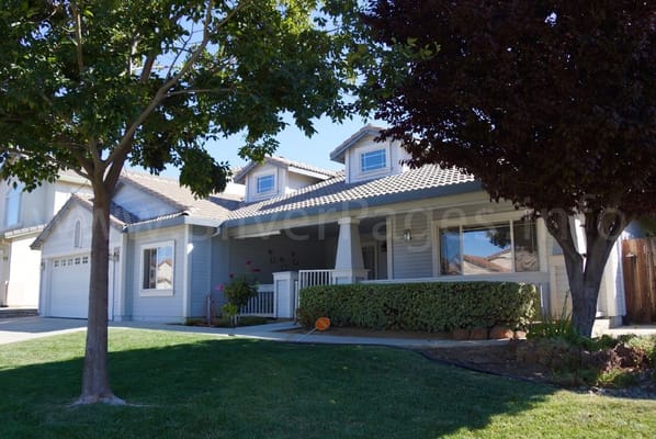 Exterior view of Tuscan Blue Assisted Living II with front yard and porch.