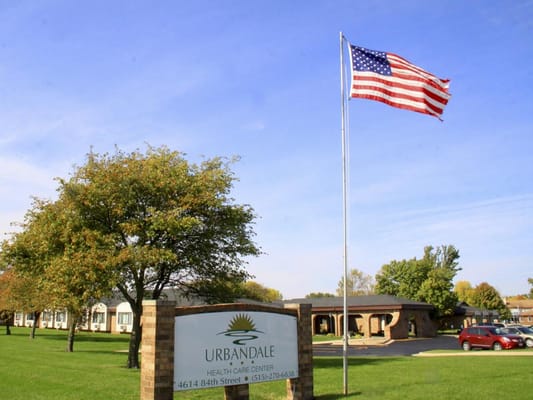 Entrance sign of Urbandale Health Care Center with American flag