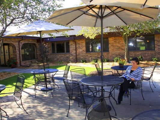 Woman reading a book on the patio under an umbrella