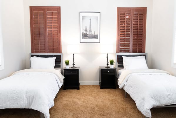 A shared resident room with two beds and lamps