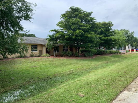 Front view of Villa Palms Assisted Living surrounded by greenery