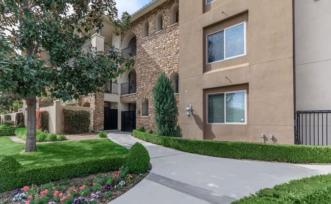 Exterior view of Villa Sorrento senior living facility with landscaped pathway.