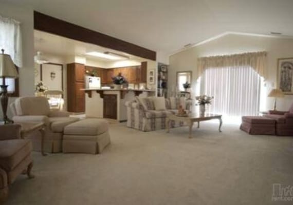 Bright and inviting living room with comfortable seating and kitchen area