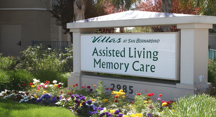 Sign for Assisted Living and Memory Care at The Villas at San Bernardino with colorful flowers