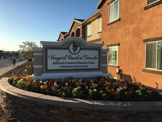 Entrance sign of Vineyard Ranch at Temecula with colorful flowers