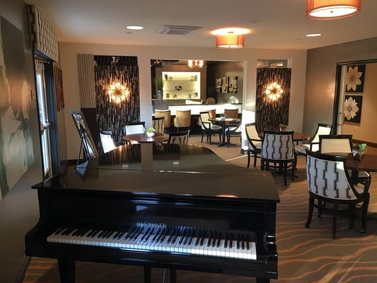 Piano in a stylish lounge area with seating and decorative lights