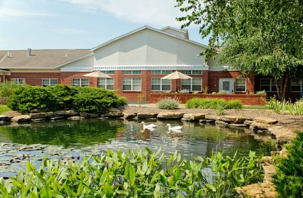 Exterior view of the rehab center with a pond