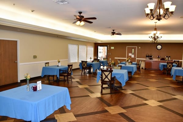 View of the dining room with blue tablecloths and wooden chairs