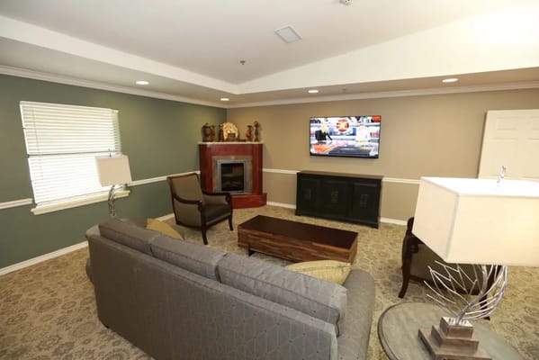 A cozy common area with a fireplace and TV