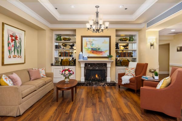 A warm and inviting living room featuring a sofa, two armchairs, a coffee table, and a fireplace.