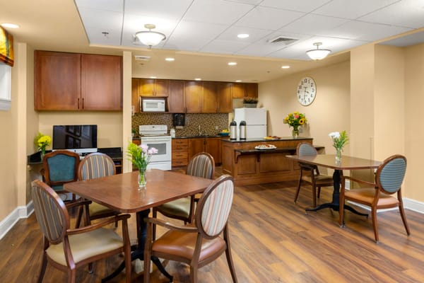 Cozy kitchen and dining area with tables and flowers at Woodholme Gardens.