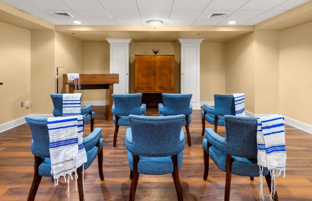 Chairs arranged in a prayer room with traditional prayer shawls