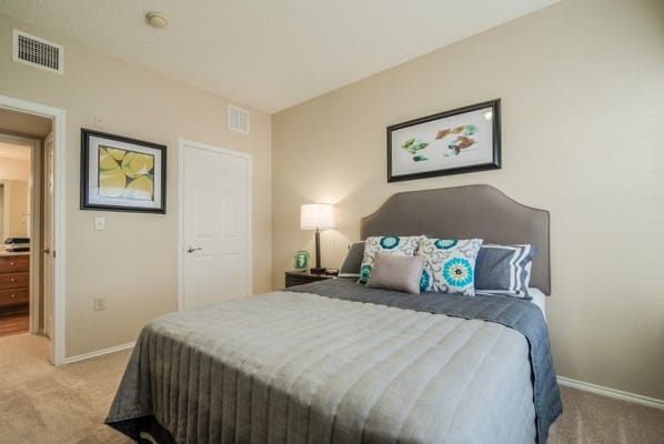 Bright bedroom with floral curtains and a single bed.