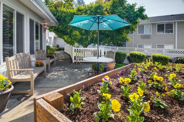 Outdoor seating area with flowers and umbrella