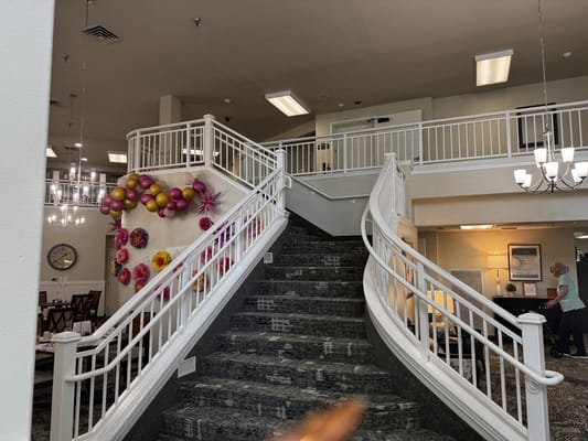 Interior view of a facility's lobby with a staircase and decor