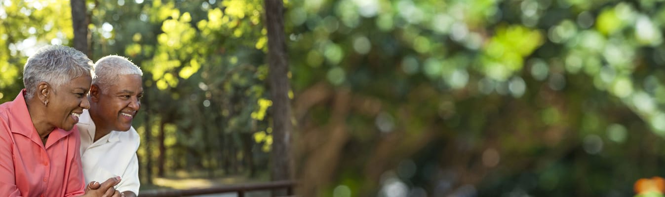 Two seniors enjoying time outdoors, smiling together.
