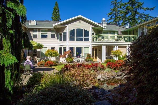 Residents enjoying a sunny outdoor space with vibrant gardens