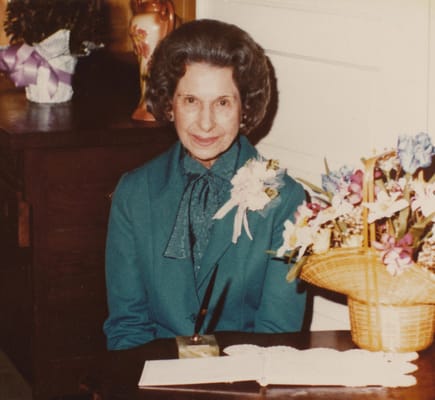 Resident posing with flowers in a common area