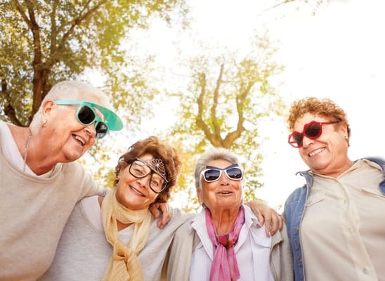 Four women enjoying a sunny outdoor moment together