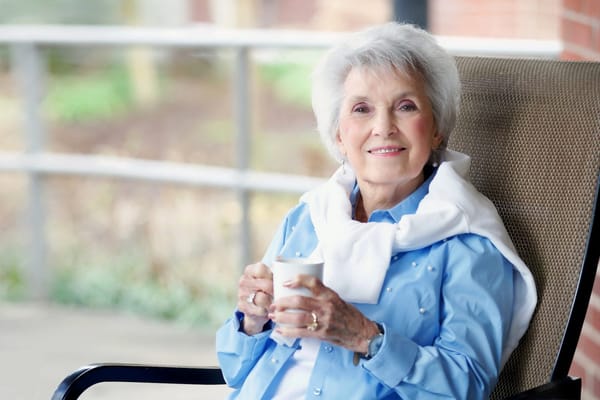 Resident enjoying tea in a garden setting