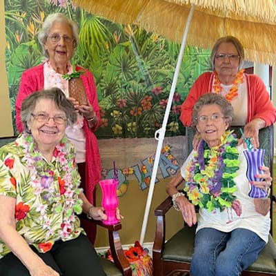 Residents celebrating with tropical drinks and leis