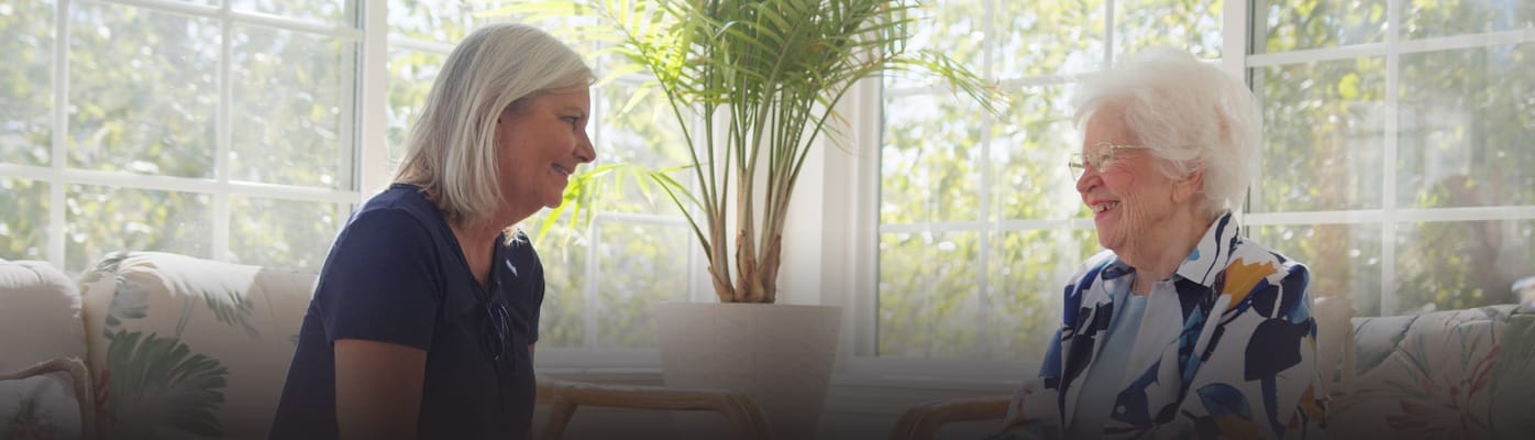 Staff member engaging happily with a resident indoors