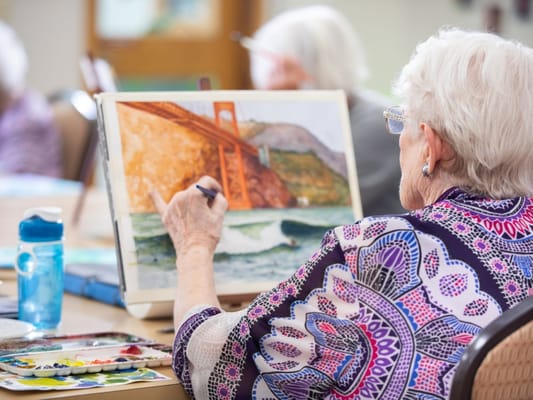 Senior resident painting in an activity room