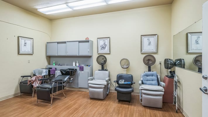 Beauty salon area with styling chairs and hair dryers