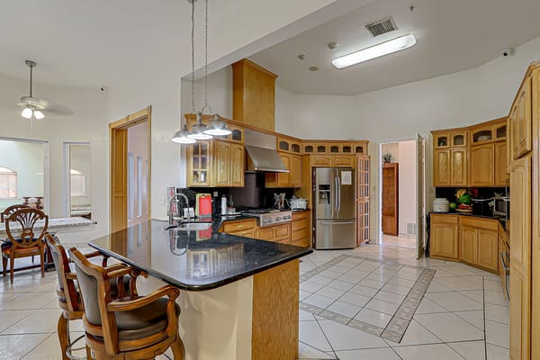 Interior kitchen area with wooden cabinets and granite countertops