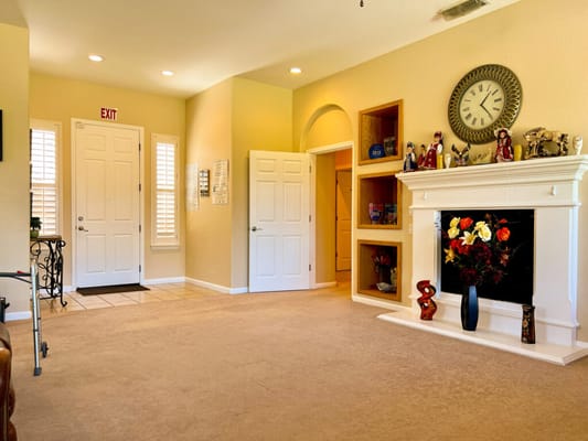 Bright common area with carpet and a decorative fireplace