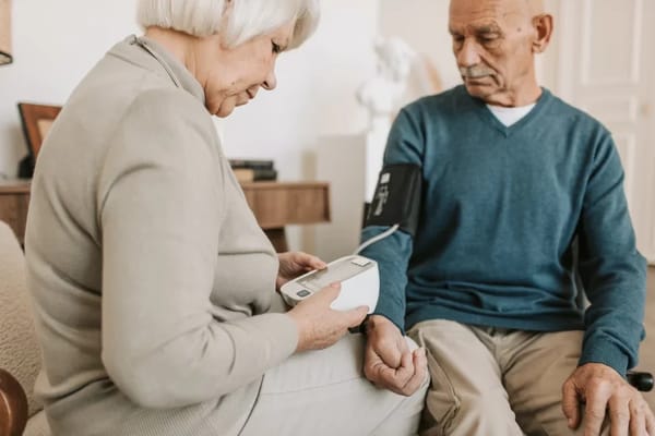 Nurse assisting an elderly resident with health monitoring