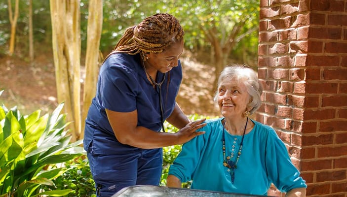 Staff assisting a resident in an outdoor space