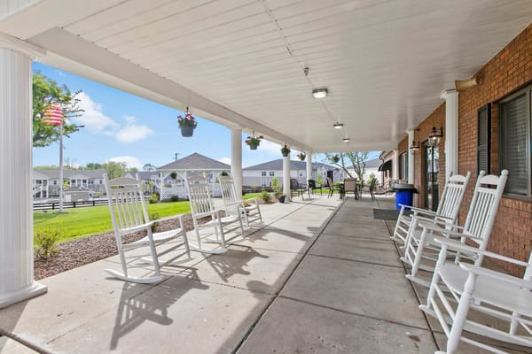 Covered porch with rocking chairs and garden view