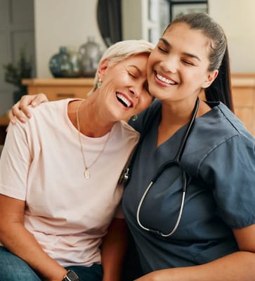 A caregiver and a resident smiling together