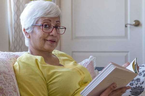 A senior woman reading a book in a cozy setting