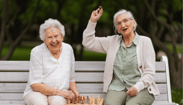 Two seniors enjoying a game of chess in a park