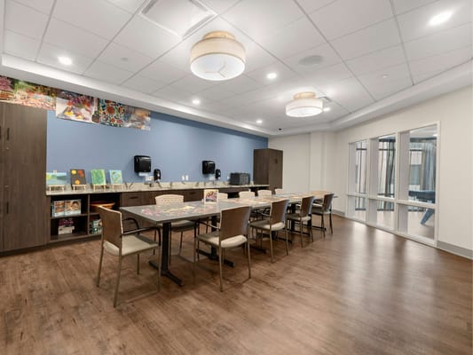 Bright common area with tables and chairs for activities