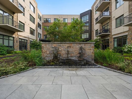 Courtyard with a stone fountain and greenery