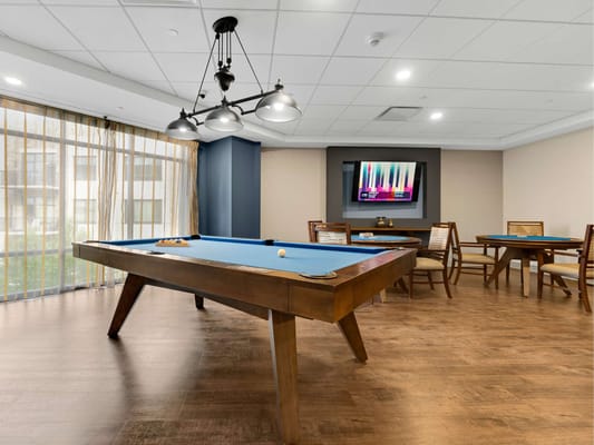 Bright game room with a pool table and seating area