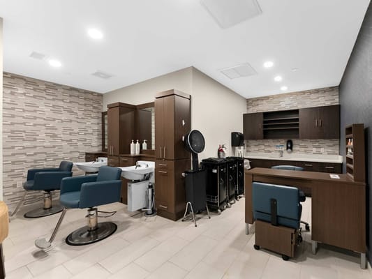Interior view of a hair salon with stylist chairs and equipment