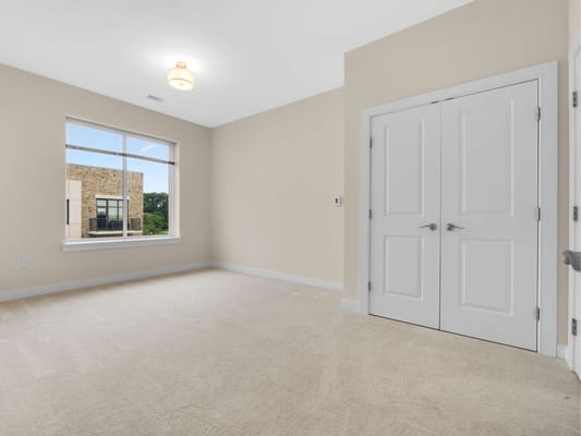 A vacant resident room with beige walls and carpet