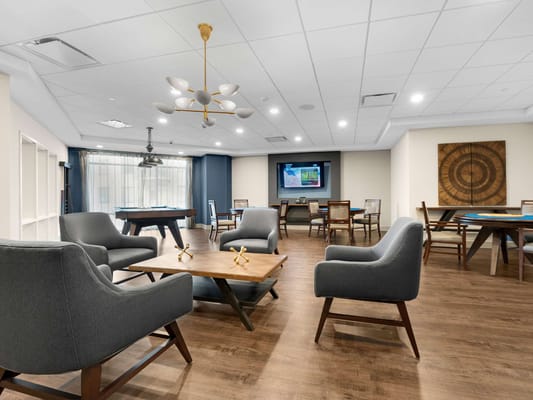 Bright common area with seating and tables for activities