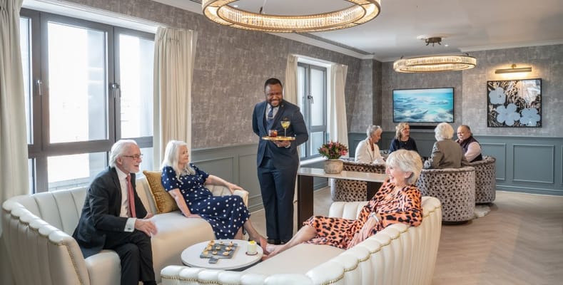 Residents and staff enjoying conversation in a cozy lounge