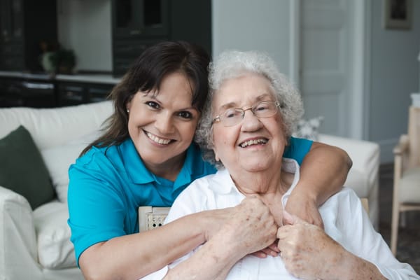 Staff member smiling with a resident in a comfortable lounge