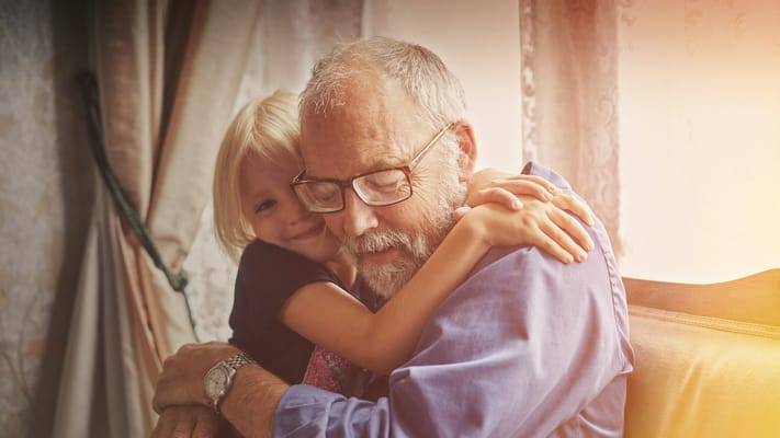 Grandparent embracing young child in a warm setting