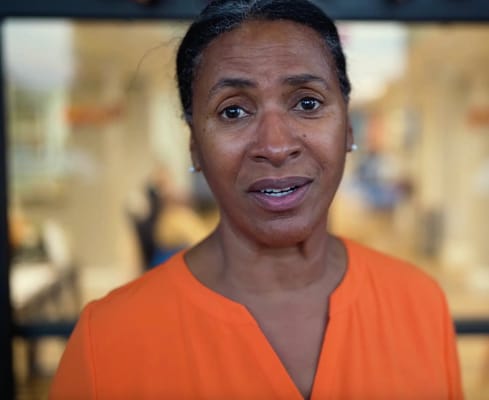 Staff member in a bright facility corridor