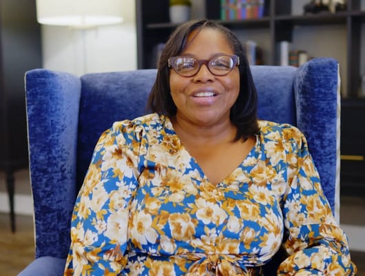 Staff member smiling in a cozy interior setting