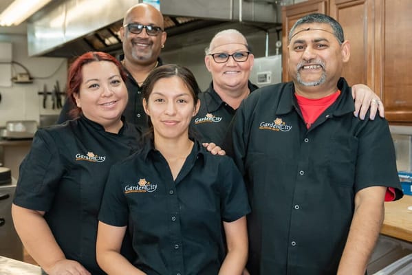 Staff members posing together in kitchen attire