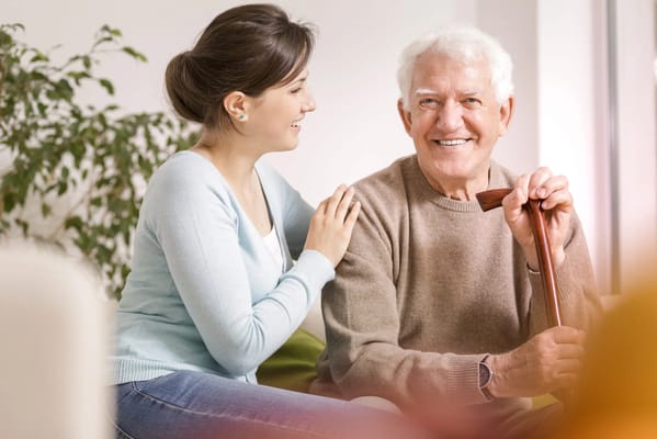 A caregiver smiling with a senior resident indoors